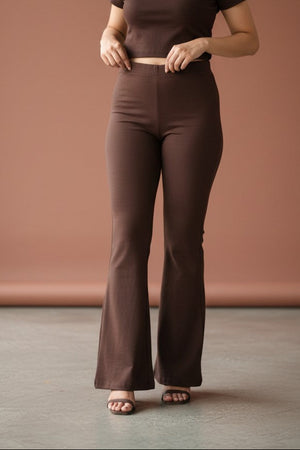 Woman wearing Pavline premium high waist brown flared pants with sleeveless black top for office and casual fashion.