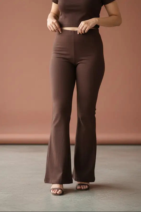 Woman wearing Pavline premium high waist brown flared pants with sleeveless black top for office and casual fashion.